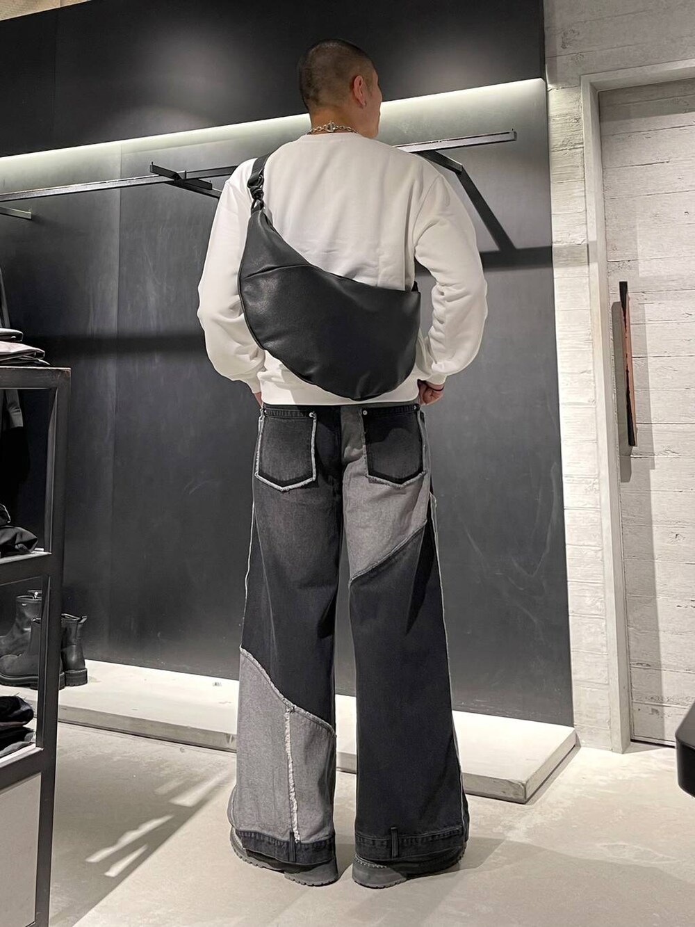 ブラック系のブーツ、ブラック系のショルダーバッグ、シルバー系のネックレスを着用したメンズの秋コーディネートの3枚目の写真