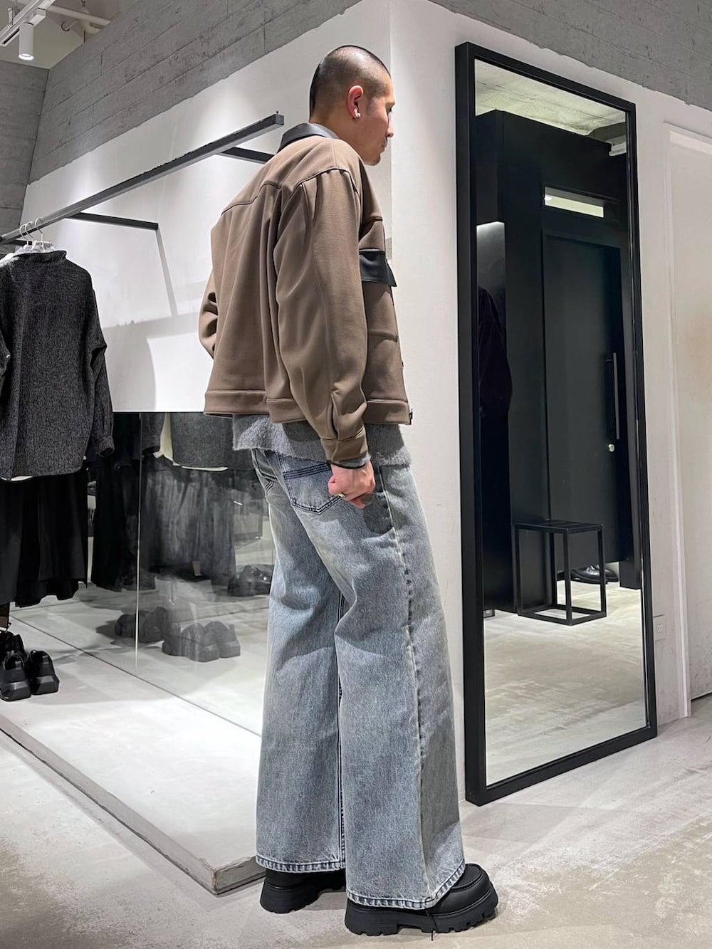 ブルー系のネクタイ、ブラック系のカーディガン/ボレロ、ブルー系のデニムパンツを着用したメンズの冬コーディネートの4枚目の写真