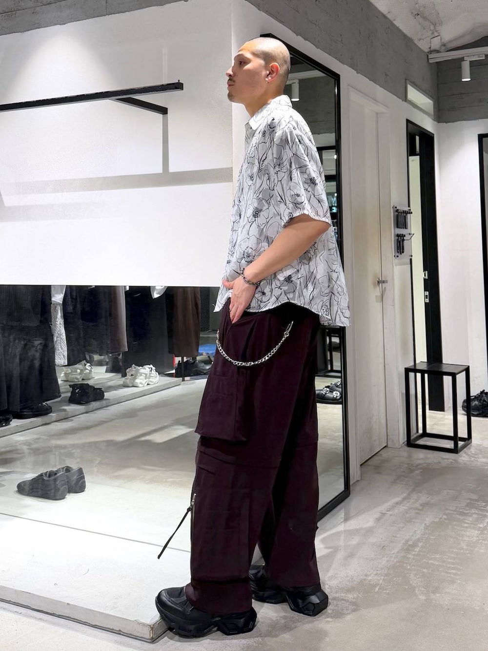 ブラック系のスニーカー、ブラウン系のカーゴパンツ、ブラック系のショルダーバッグを着用したメンズの夏コーディネートの2枚目の写真