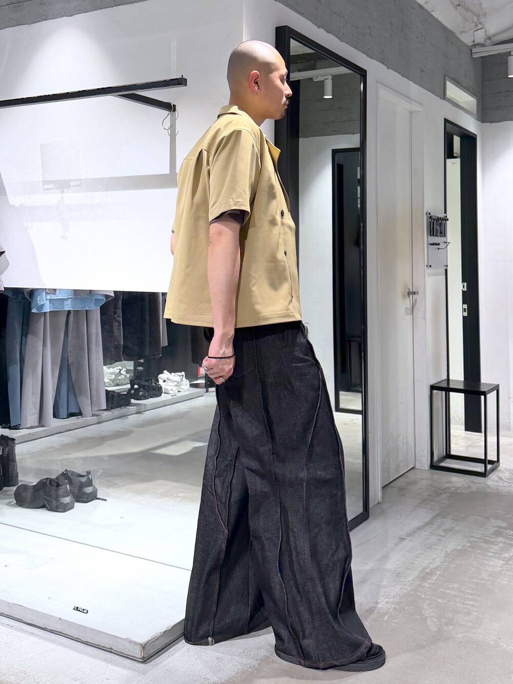 ブラック系のデニムパンツ、ブラック系のサンダル、グレー系のTシャツ/カットソーを着用したメンズの夏コーディネートの4枚目の写真