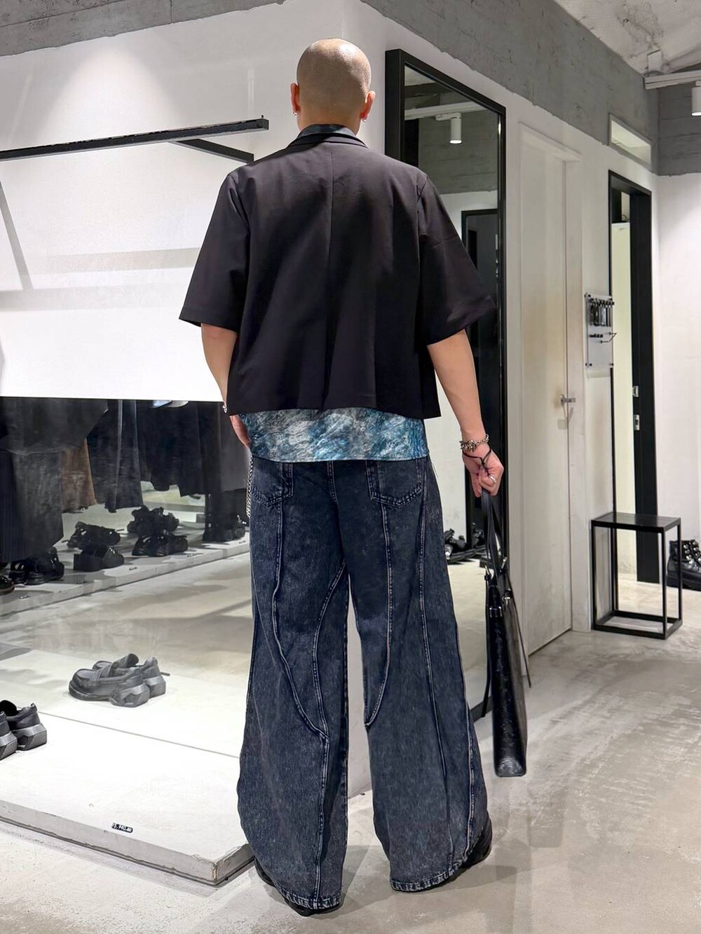 ブラック系のスニーカー、ブルー系のデニムパンツ、ブルー系のシャツ/ブラウスを着用したメンズの夏コーディネートの3枚目の写真