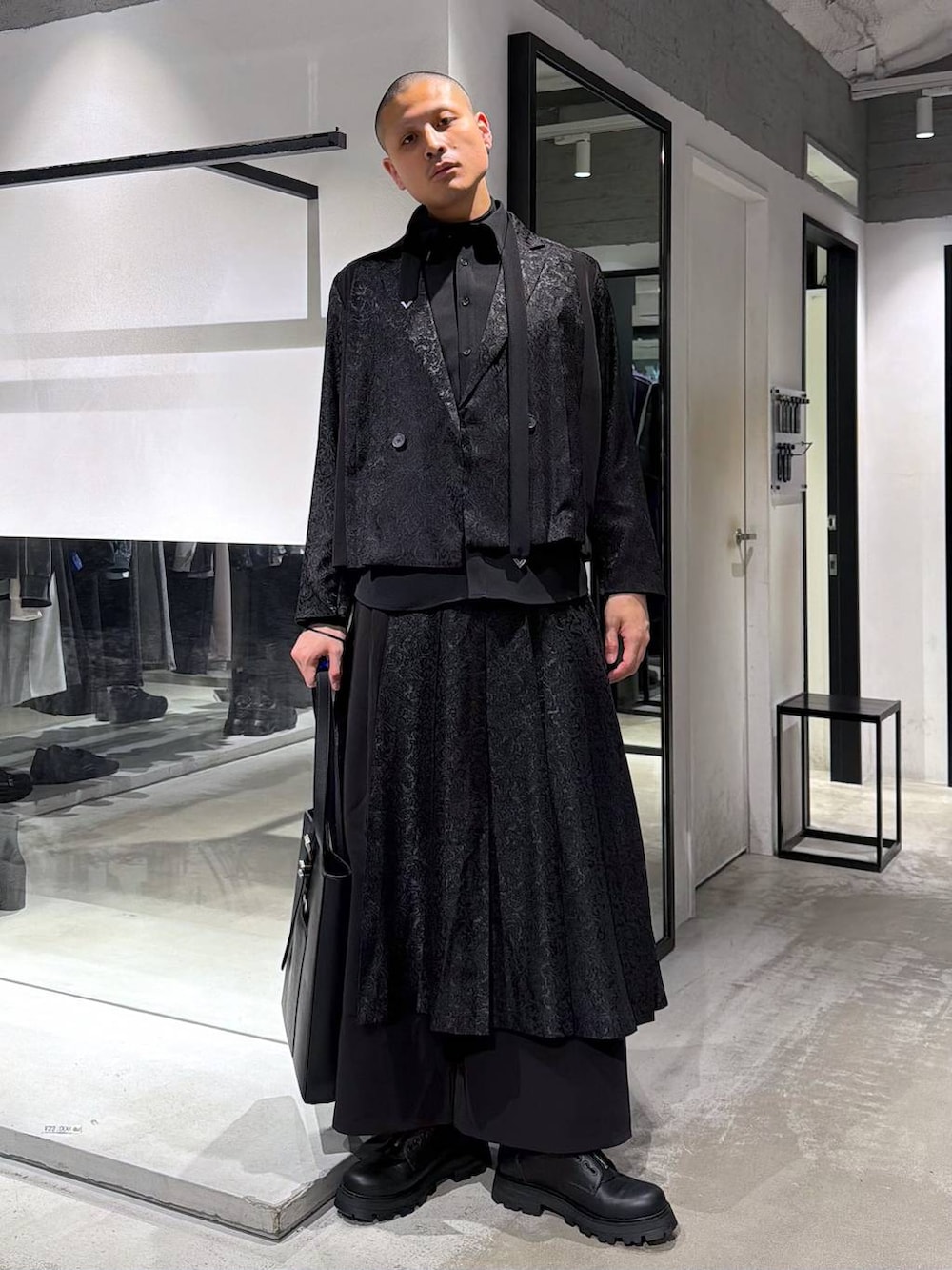 ブラック系のトートバッグ、ブラック系のその他パンツ、ブラック系のドレスシューズを着用したメンズの春コーディネートの2枚目の写真