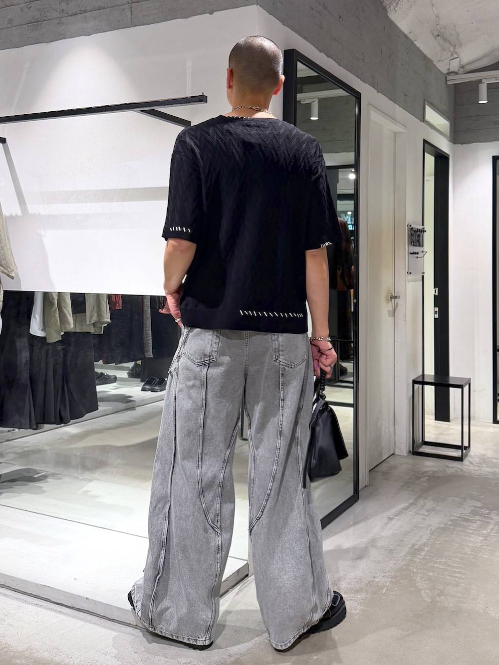 ブラック系のローファー、ブラック系のショルダーバッグ、グレー系のデニムパンツを着用したメンズの夏コーディネートの3枚目の写真