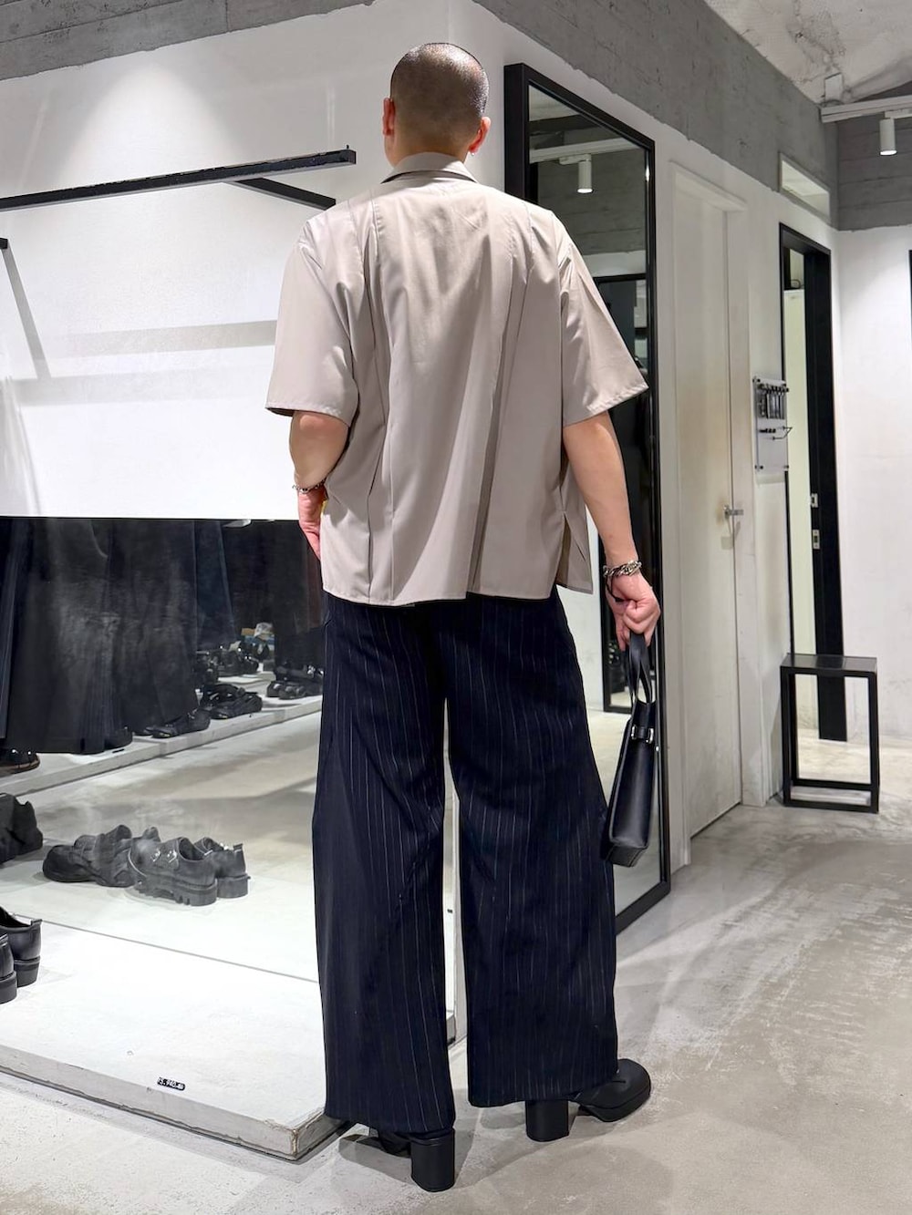 ブラック系のサンダル、ブルー系のスラックス、ベージュ系のシャツ/ブラウスを着用したメンズの夏コーディネートの3枚目の写真