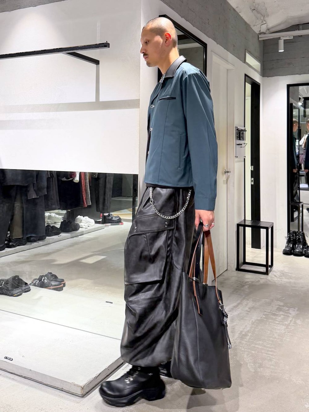 グリーン系のシャツ/ブラウス、ブラック系のブーツ、ブラック系のTシャツ/カットソーを着用したメンズの秋コーディネートの2枚目の写真