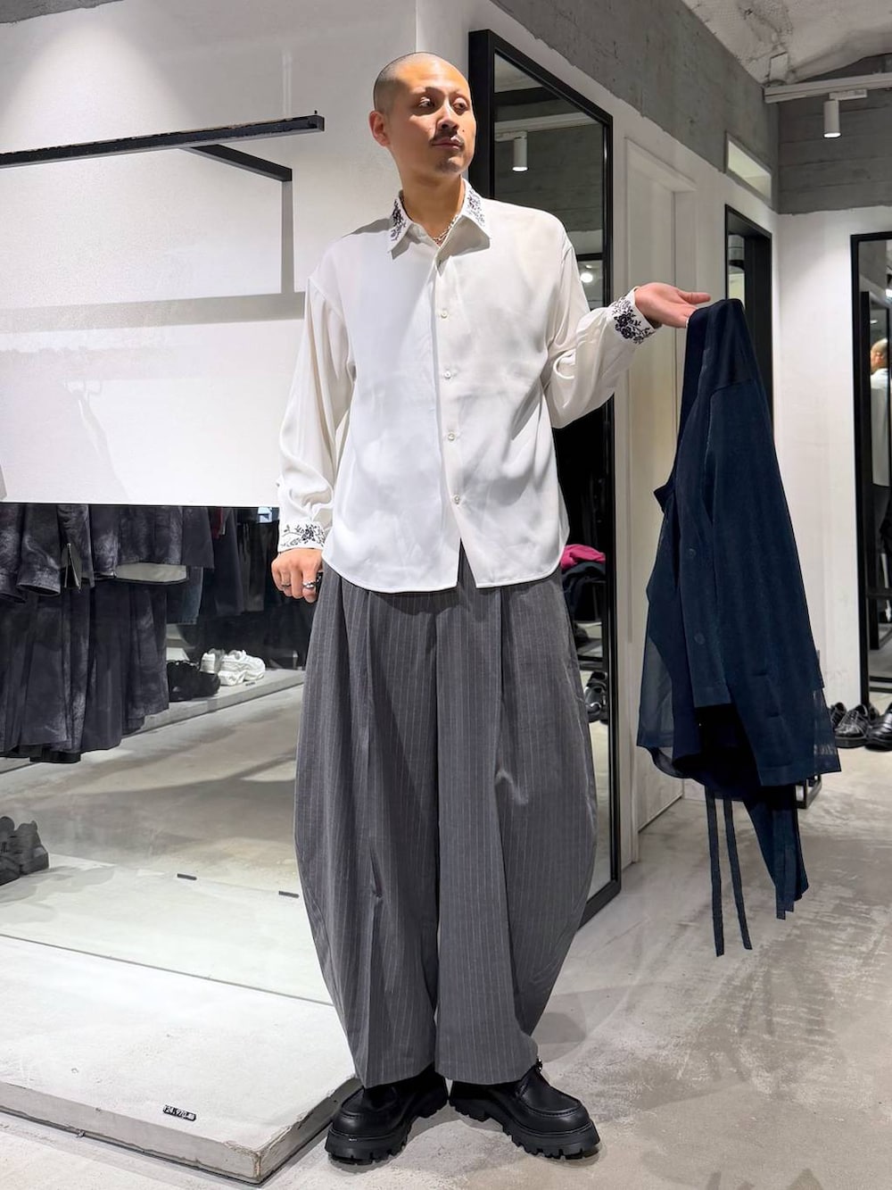 ブラック系のスラックス、ブラック系のローファー、ブルー系のカーディガン/ボレロを着用したメンズの秋コーディネートの5枚目の写真
