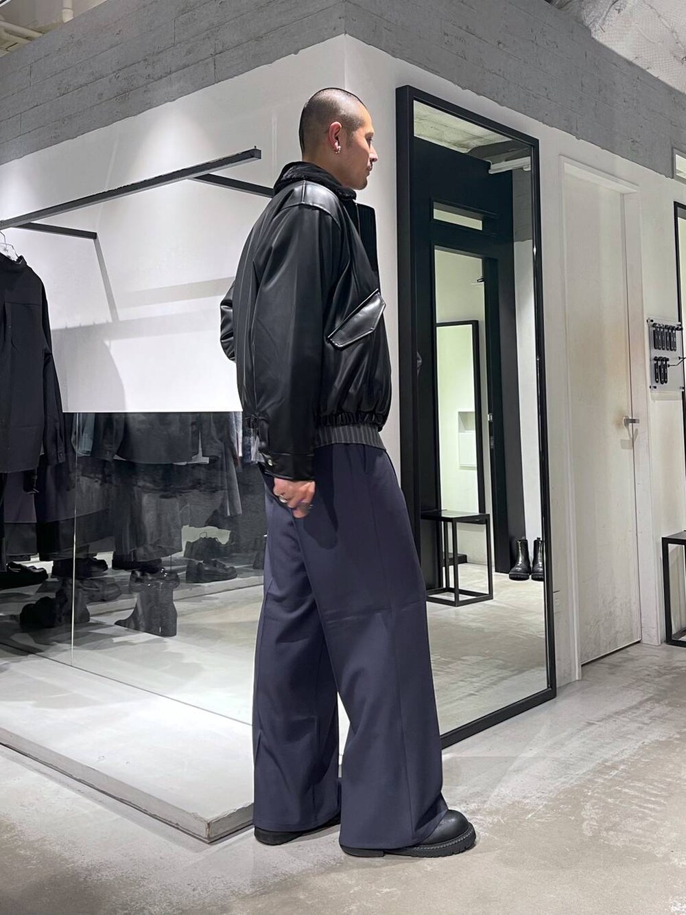 ブラック系のブルゾン、ブルー系のスラックス、ブラック系のショルダーバッグを着用したメンズの冬コーディネートの4枚目の写真