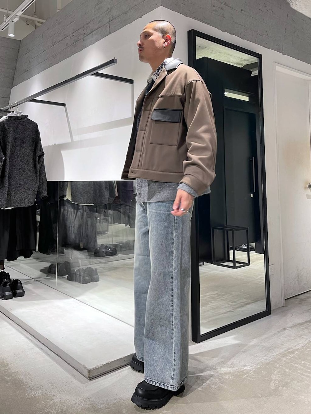 ブルー系のネクタイ、ブラック系のカーディガン/ボレロ、ブルー系のデニムパンツを着用したメンズの冬コーディネートの2枚目の写真