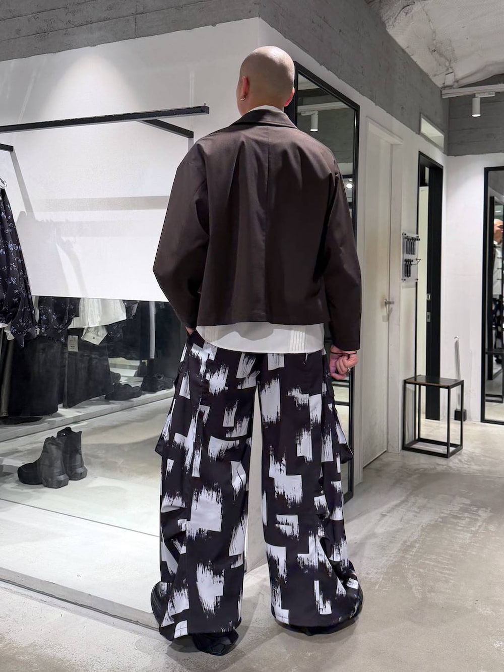 ブラック系のスニーカー、ホワイト系のシャツ/ブラウス、ブラウン系のブルゾンを着用したメンズの春コーディネートの3枚目の写真