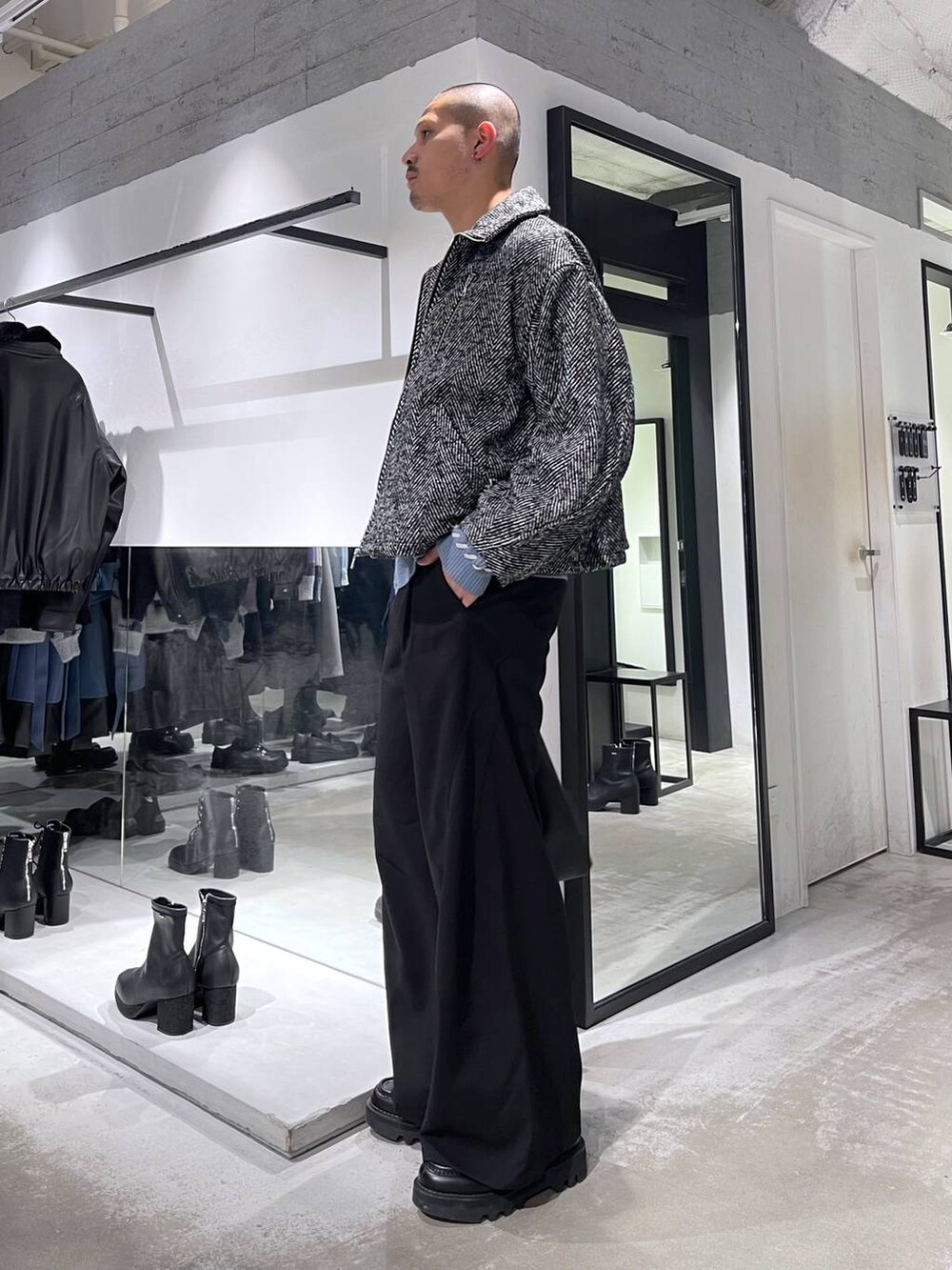 ブラック系のトートバッグ、グレー系のブルゾン、ブラック系のスラックスを着用したメンズの冬コーディネートの2枚目の写真