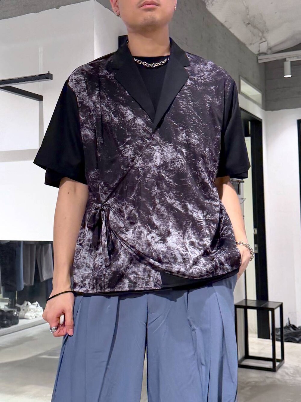 ブラック系のTシャツ/カットソー、ブラック系のサンダル、ブルー系のスラックスを着用したメンズの春コーディネートの5枚目の写真