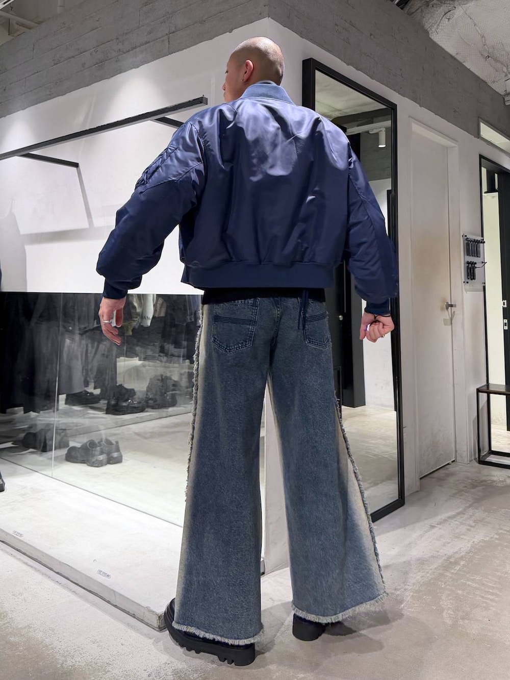 ブラック系のニット/セーター、ブラック系のドレスシューズ、ブルー系のMA-1を着用したメンズの冬コーディネートの2枚目の写真