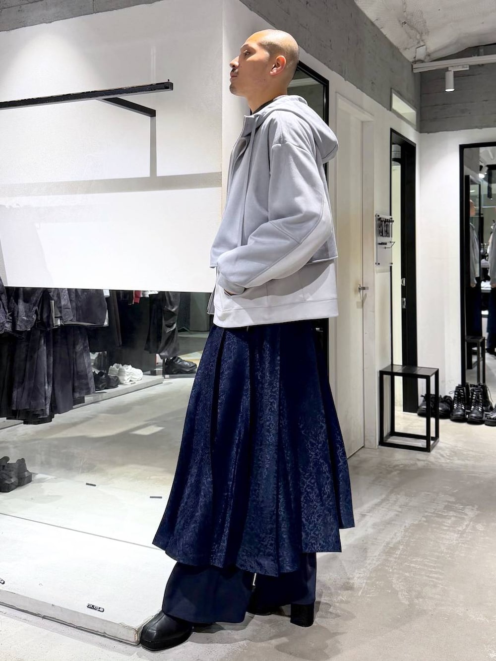 グレー系のニット/セーター、ブラック系のブーツ、ブルー系のその他パンツを着用したメンズの秋コーディネートの2枚目の写真
