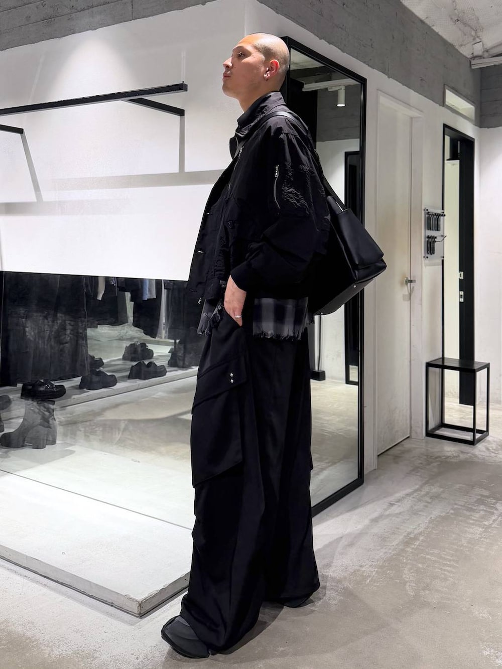 ブラック系のカーゴパンツ、ブラック系のショルダーバッグ、ブラック系のシャツ/ブラウスを着用したメンズの春コーディネートの2枚目の写真