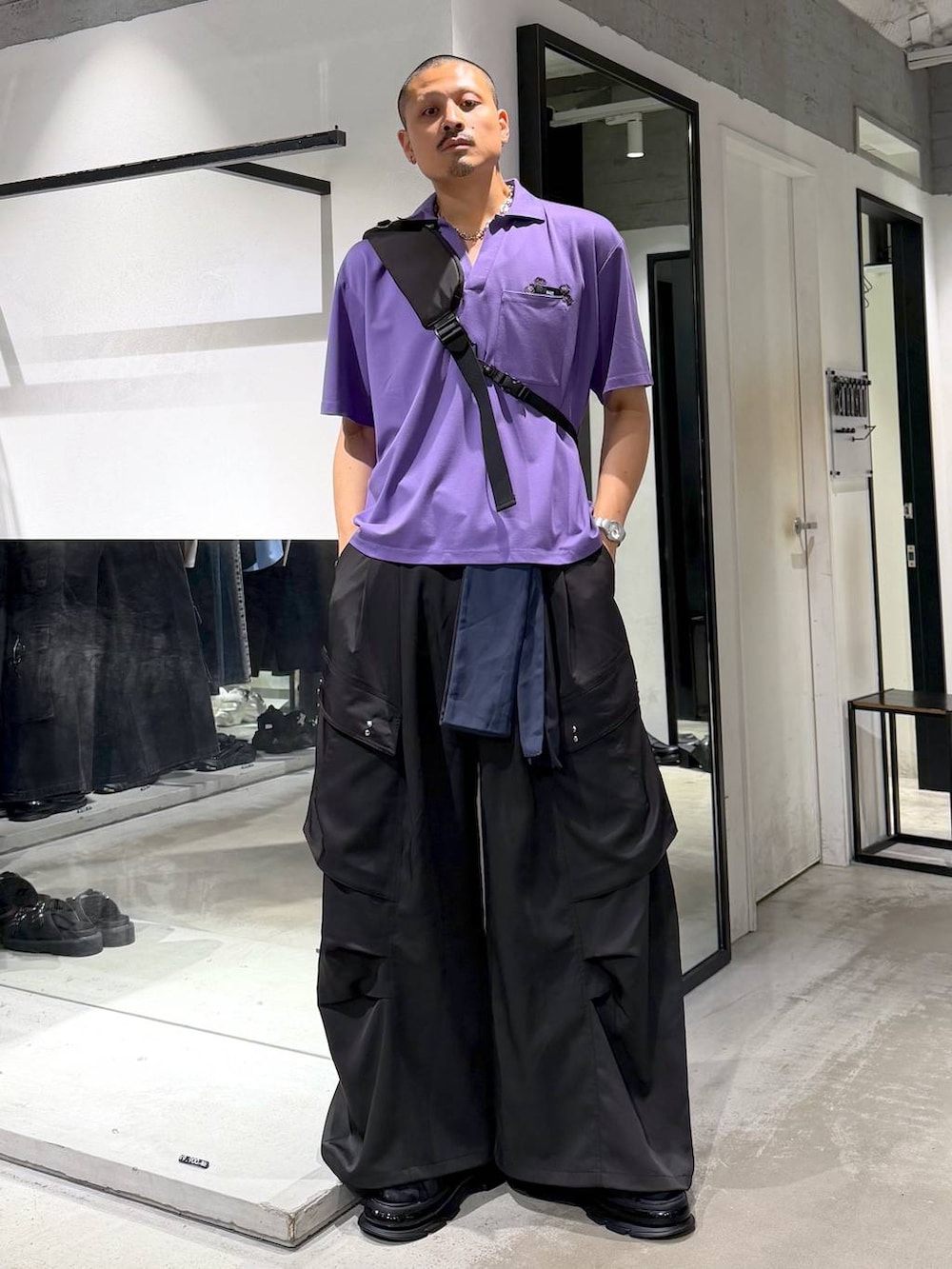 パープル系のTシャツ/カットソー、ブラック系のショルダーバッグ、ブラック系のカーゴパンツを着用したメンズの夏コーディネートの5枚目の写真
