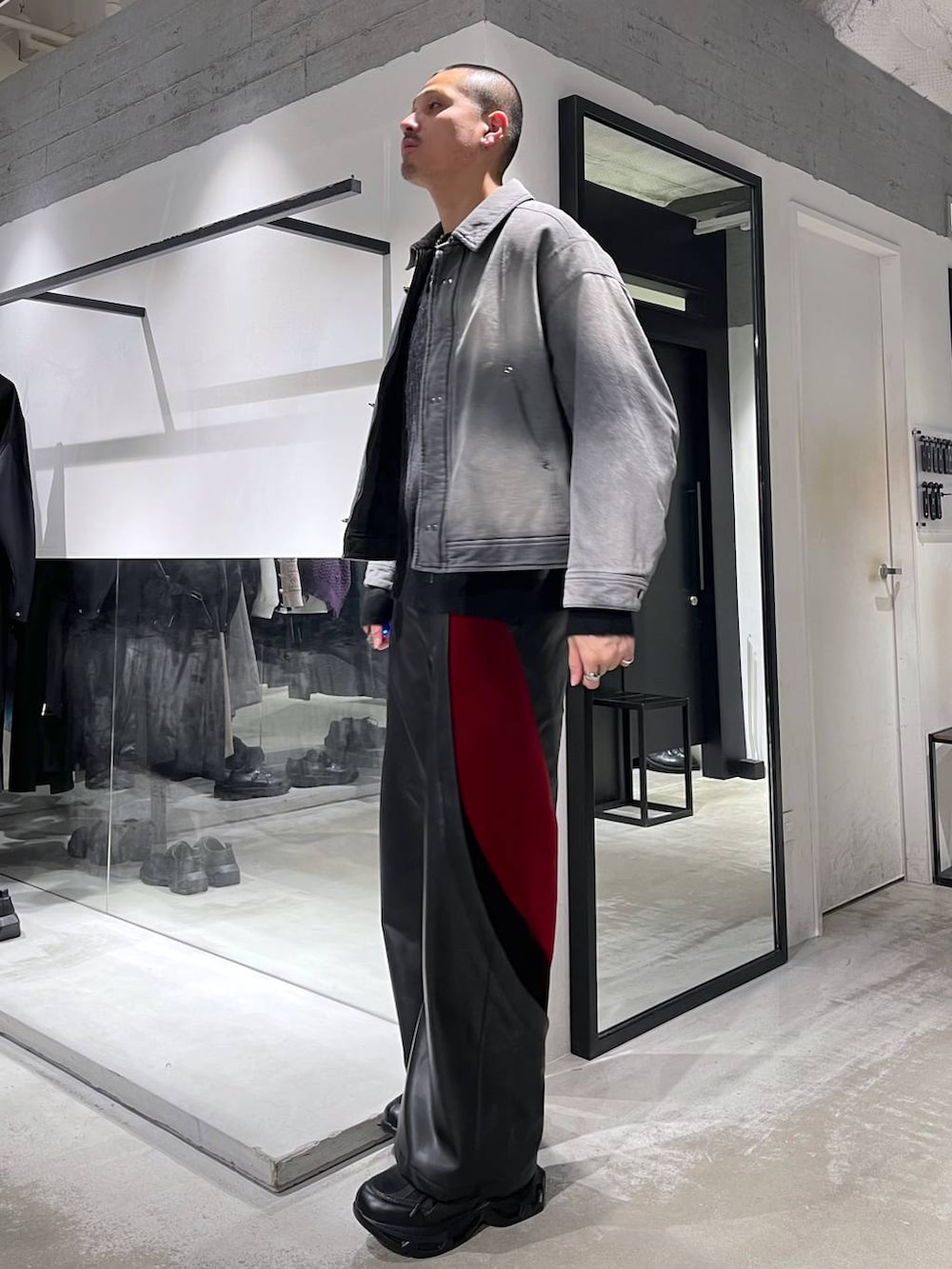 ブラック系のスニーカー、レッド系のその他パンツ、グレー系のブルゾンを着用したメンズの冬コーディネートの2枚目の写真