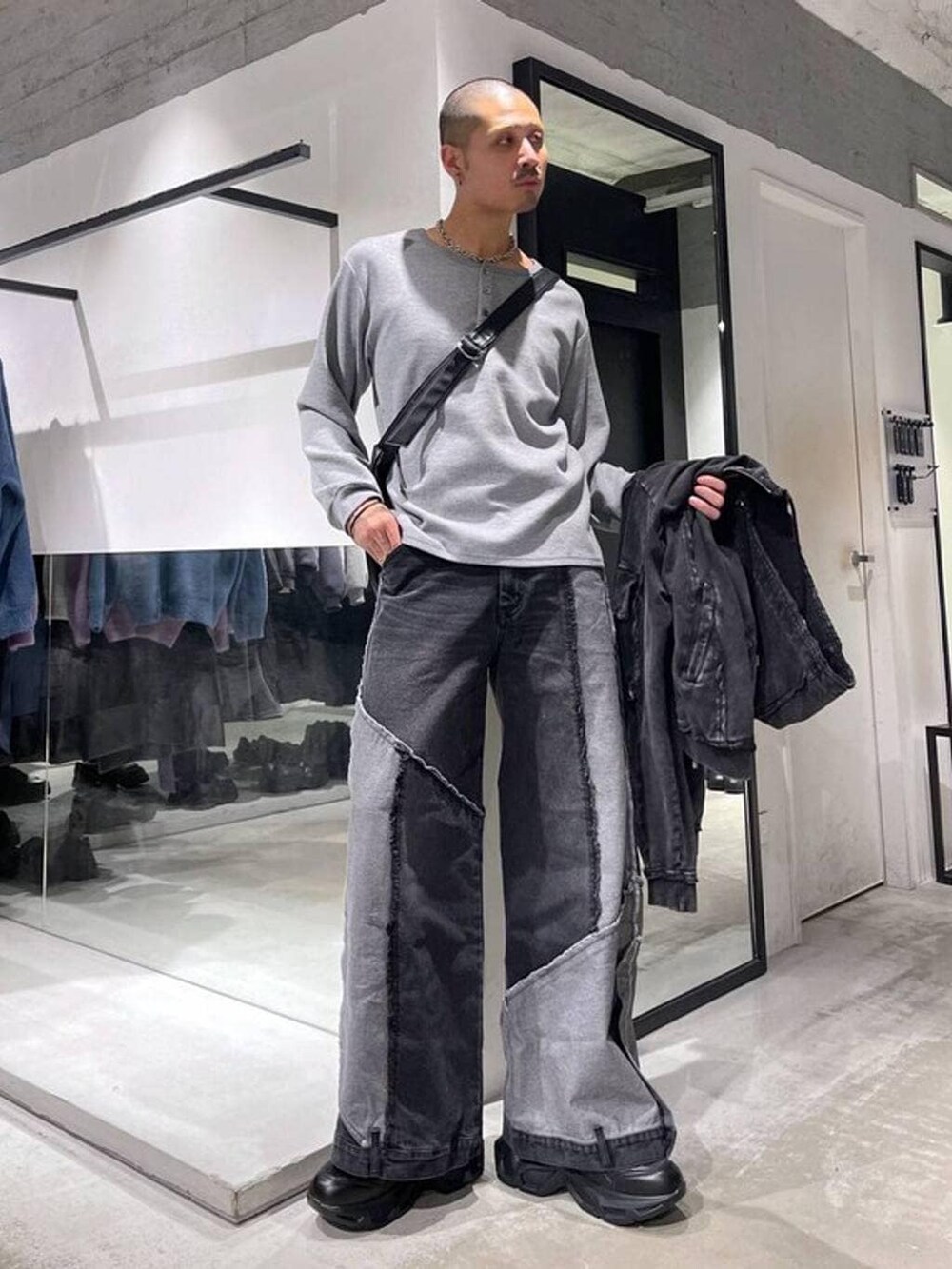 ブラック系のスニーカー、ブラック系のパーカー、ブラック系のデニムパンツを着用したメンズの冬コーディネートの6枚目の写真