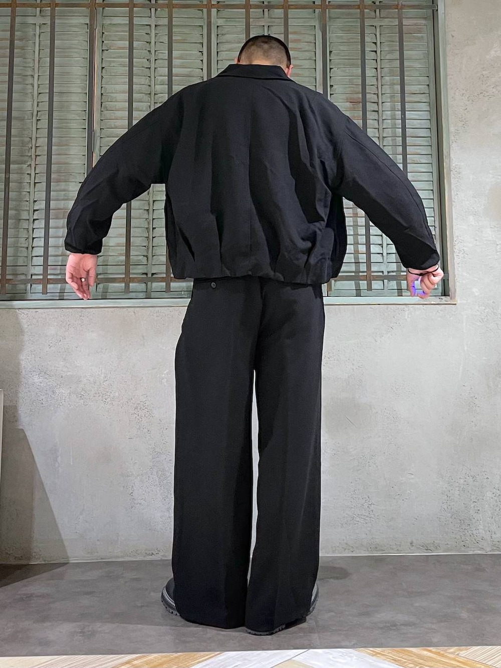 ブラック系のブーツ、ホワイト系のニット/セーター、シルバー系のネックレスを着用したメンズの秋コーディネートの3枚目の写真