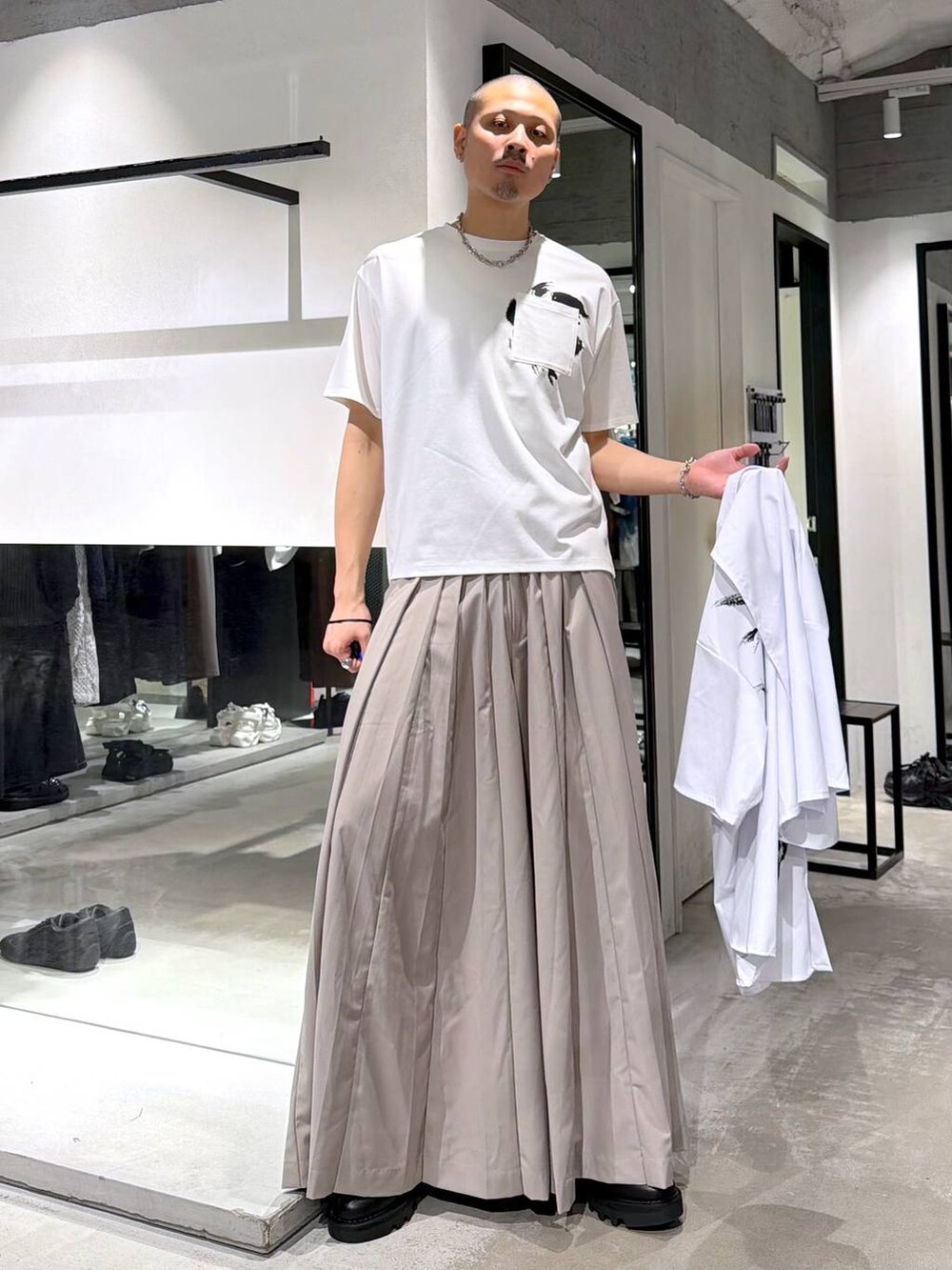ブラック系のドレスシューズ、ブラック系のトートバッグ、ベージュ系のスラックスを着用したメンズの夏コーディネートの5枚目の写真