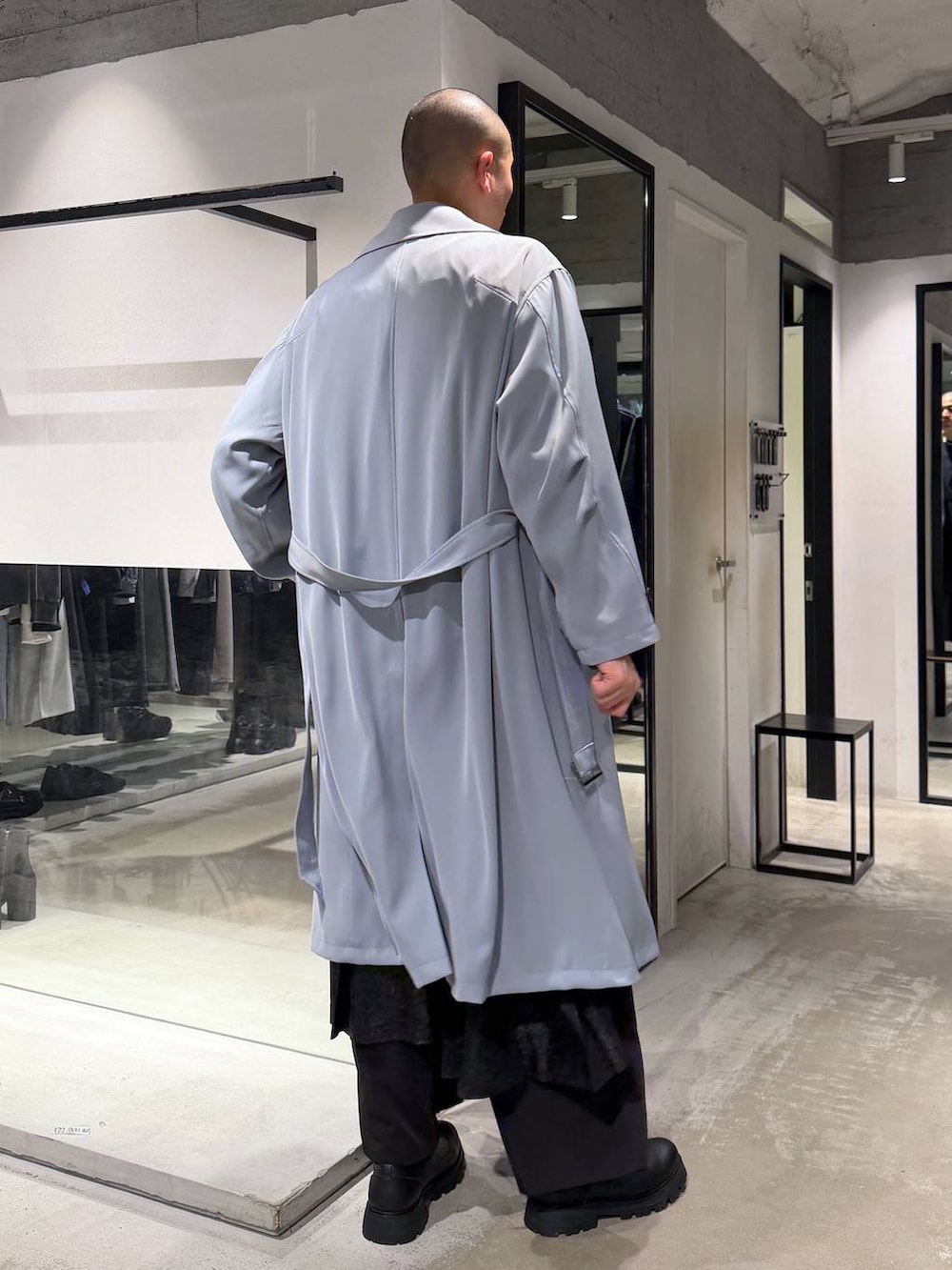 ブラック系のその他パンツ、ブラック系のドレスシューズ、グリーン系のトレンチコートを着用したメンズの春コーディネートの4枚目の写真