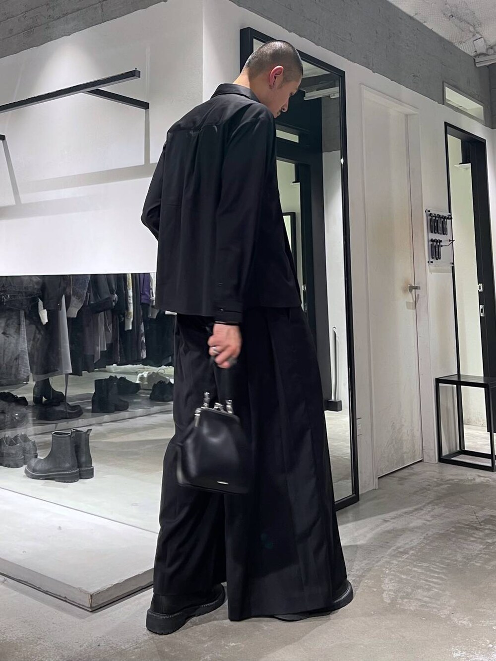 ブラック系のショルダーバッグ、ブラック系のブーツ、ブラック系のスラックスを着用したメンズの秋コーディネートの4枚目の写真