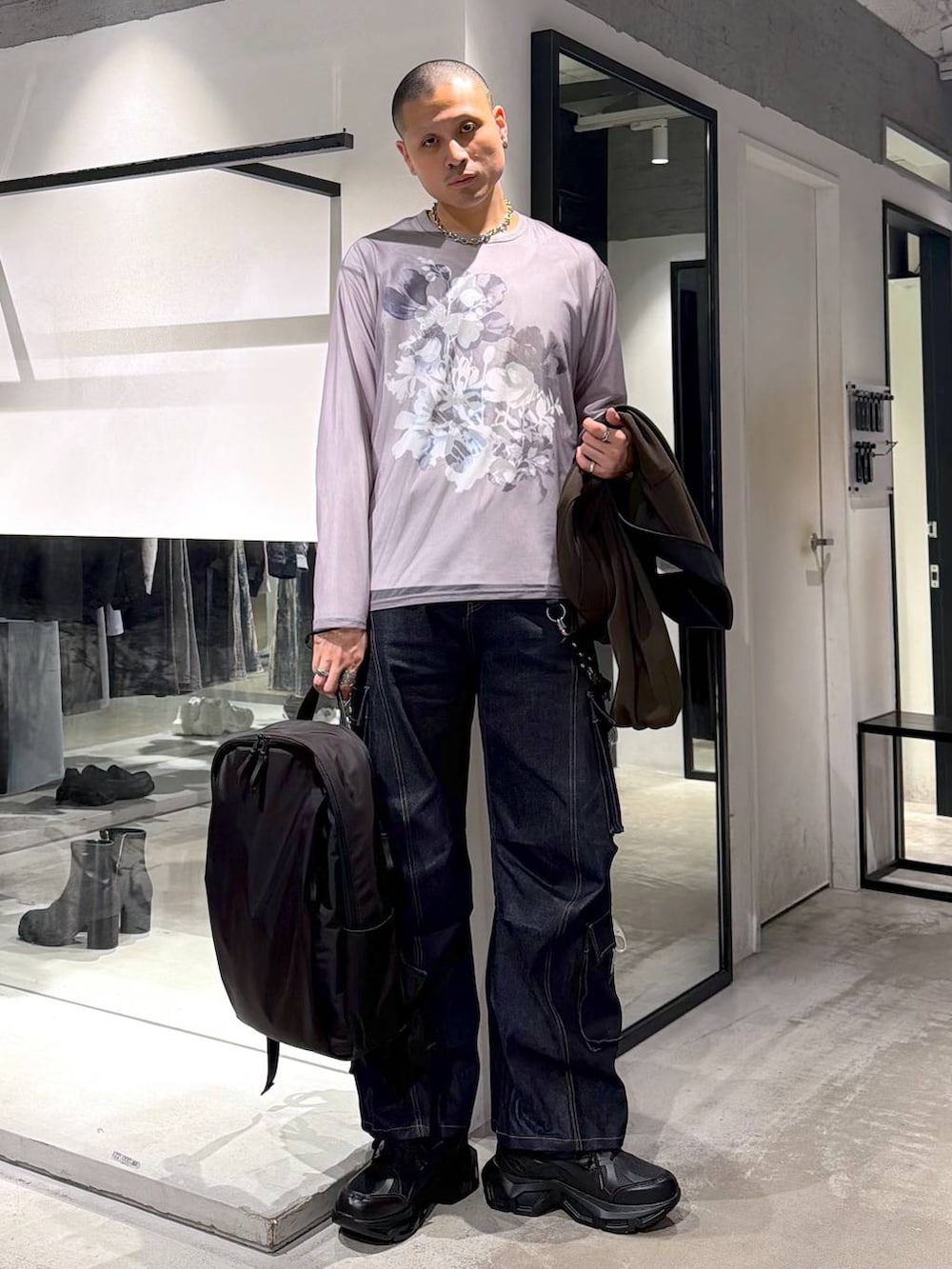 ブラック系のスニーカー、ブラウン系のブルゾン、ブラック系のバックパック/リュックを着用したメンズの春コーディネートの4枚目の写真