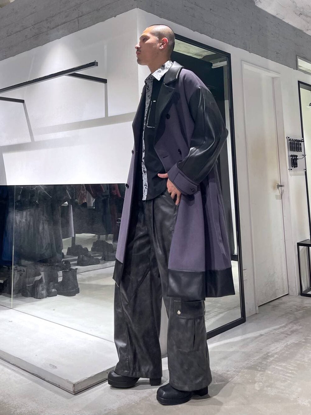 パープル系のトレンチコート、グレー系のカーゴパンツ、ブラック系のブーツを着用したメンズの冬コーディネートの2枚目の写真