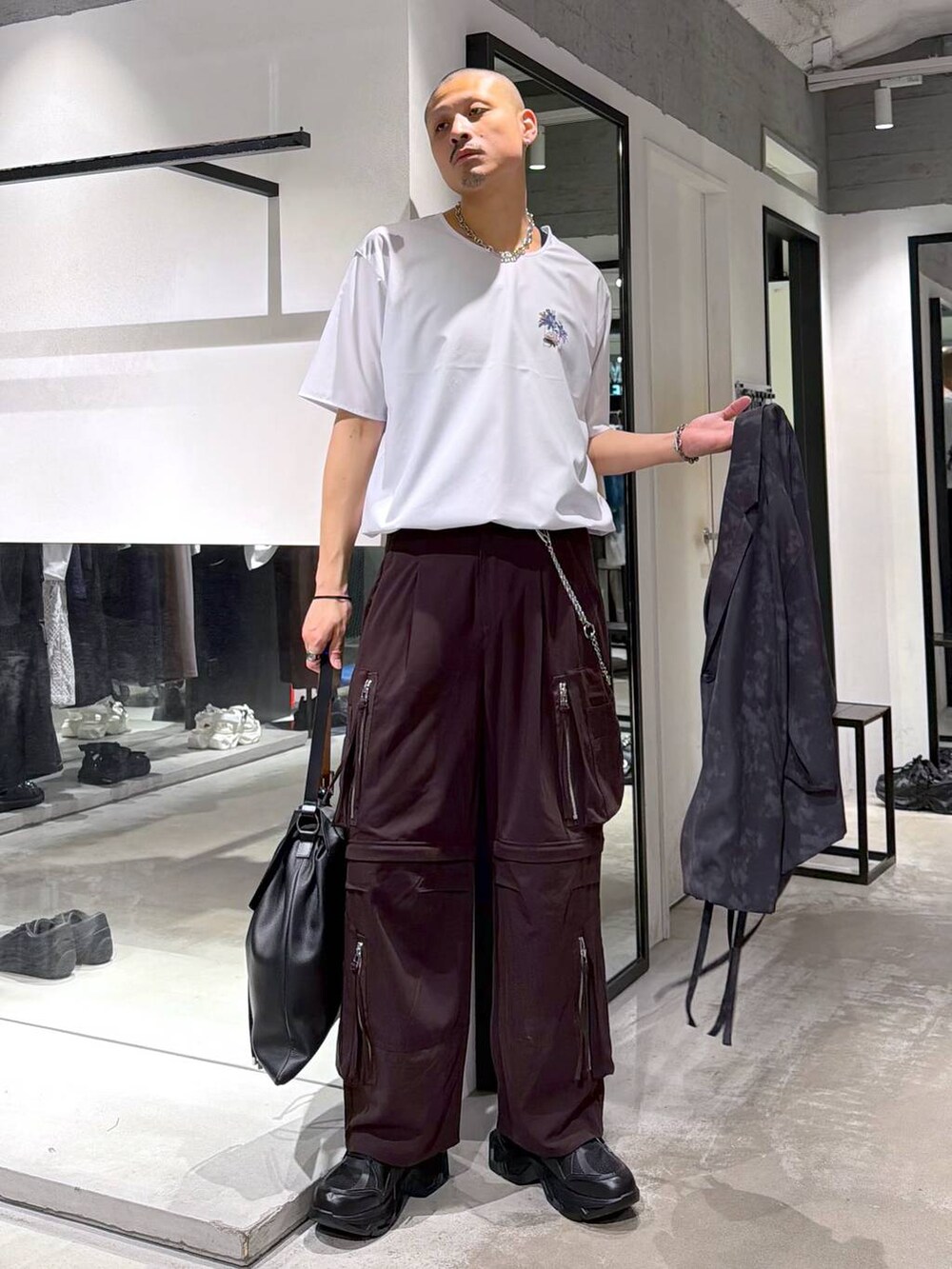 ブラック系のスニーカー、ブラウン系のカーゴパンツ、グレー系のテーラードジャケットを着用したメンズの夏コーディネートの5枚目の写真