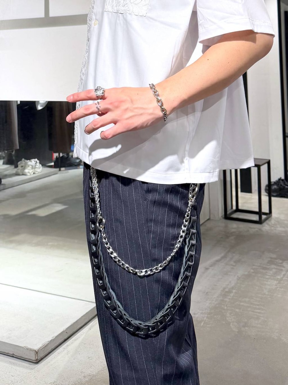 ブラック系のトートバッグ、ブルー系のスラックス、ブラック系のドレスシューズを着用したメンズの春コーディネートの5枚目の写真