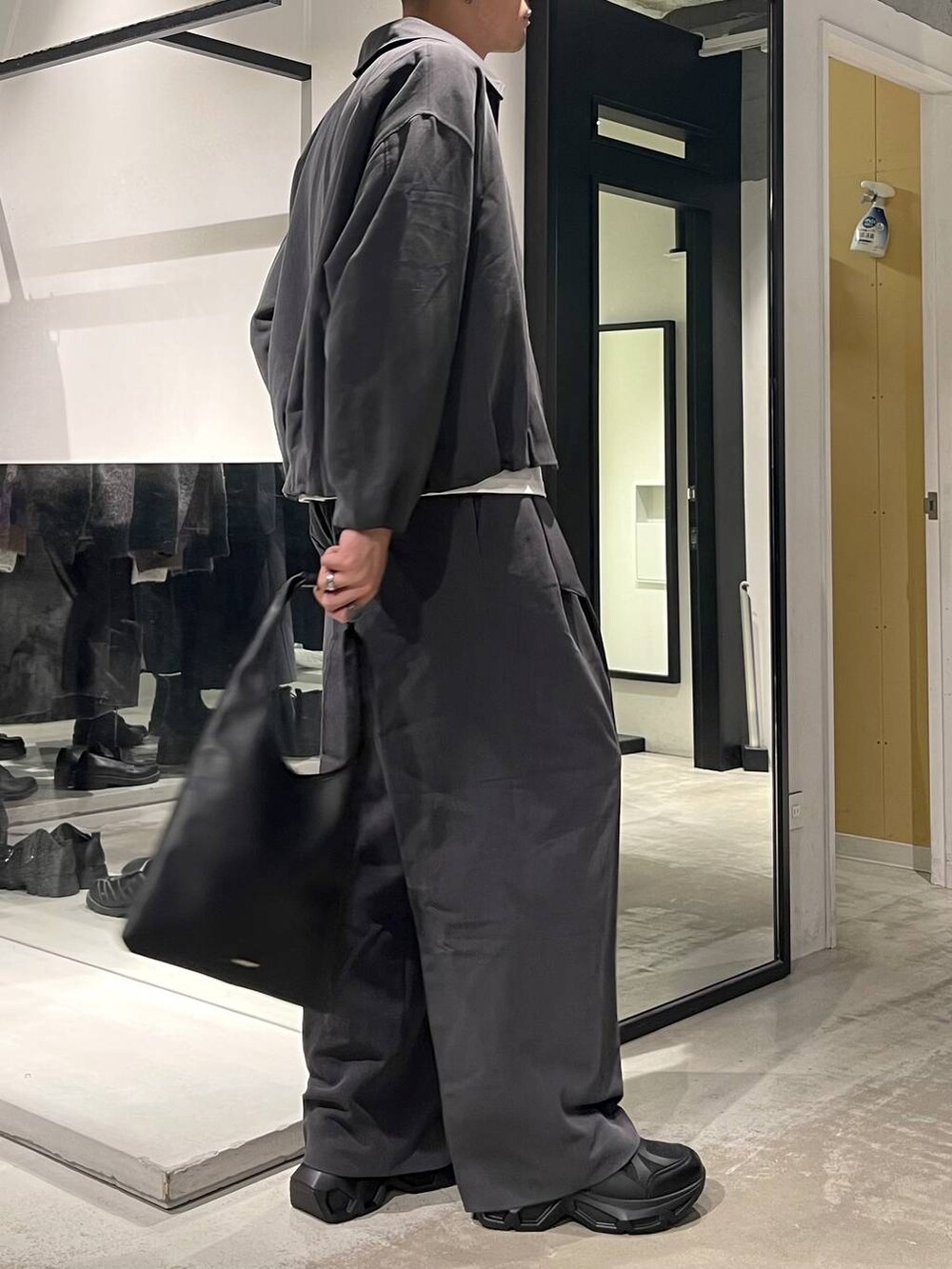 ブラック系のトートバッグ、ブラック系のスニーカー、ホワイト系のTシャツ/カットソーを着用したメンズの秋コーディネートの5枚目の写真