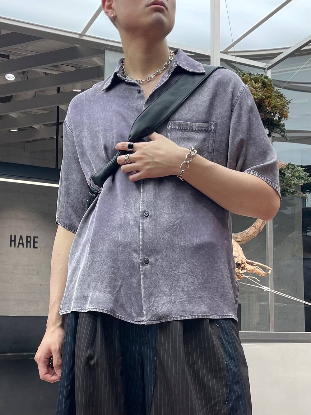 ブラック系のサンダル、パープル系のシャツ/ブラウス、ブラック系のショルダーバッグを着用したメンズの春コーディネートの2枚目の写真