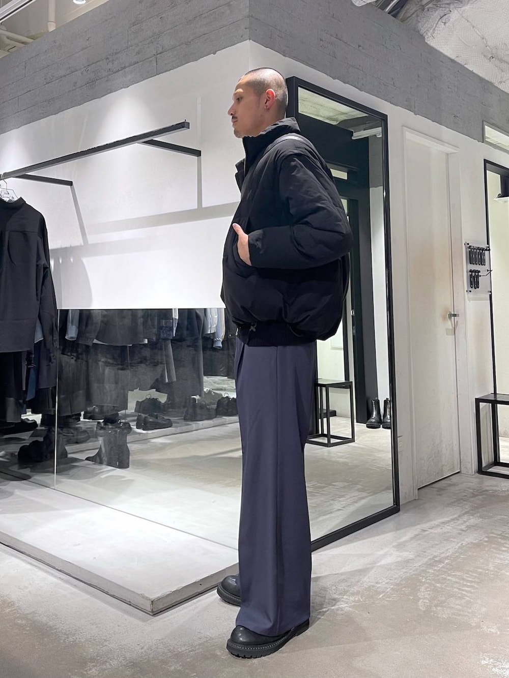 ブラック系のダウンジャケット/コート、ブラック系のブーツ、ブラック系のショルダーバッグを着用したメンズの冬コーディネートの2枚目の写真