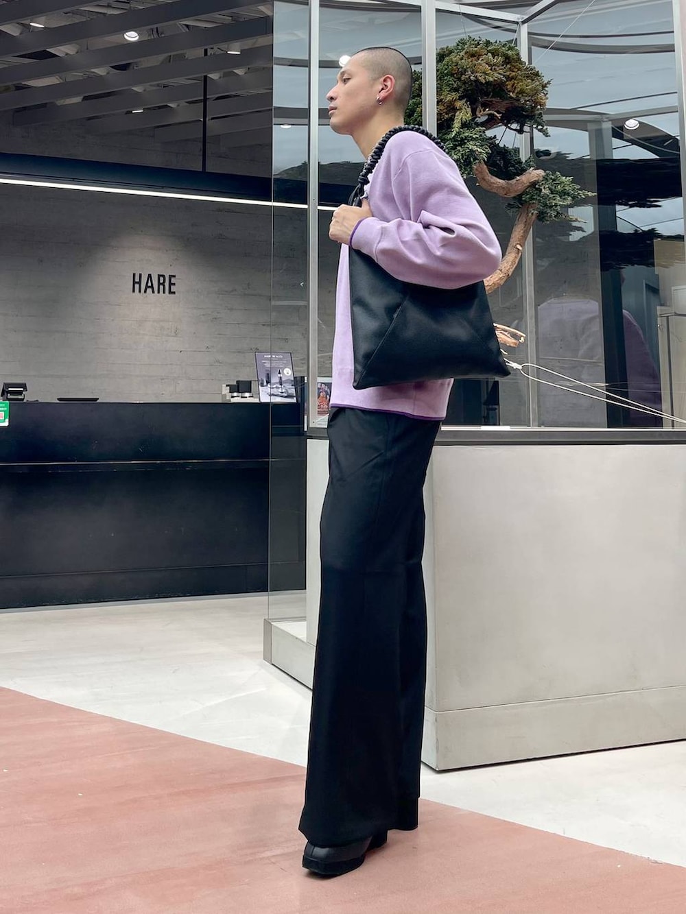 ブラック系のトートバッグ、ブラック系のブーツ、ブラック系のスラックスを着用したメンズの秋コーディネートの2枚目の写真