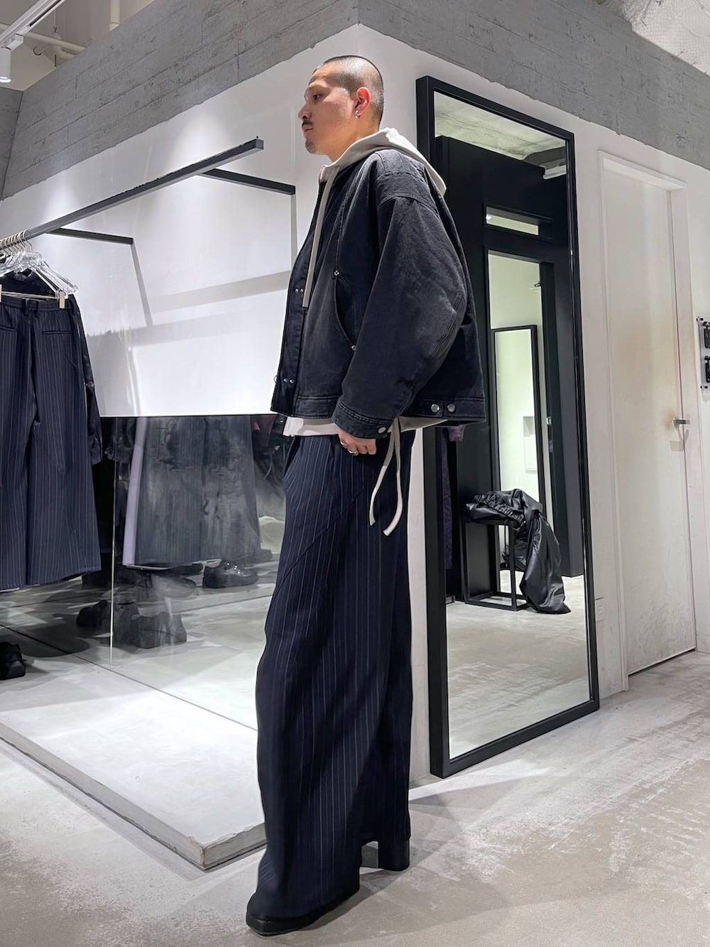 ブルー系のスラックス、ブラック系のブーツ、シルバー系のネックレスを着用したメンズの冬コーディネートの2枚目の写真