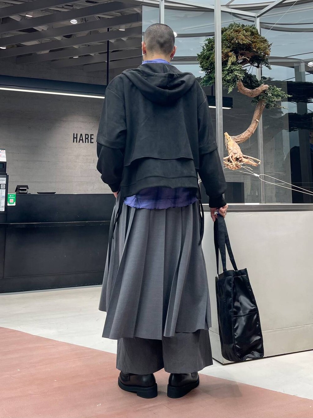 ブラック系のトートバッグ、グレー系のその他パンツ、ブラック系のローファーを着用したメンズの秋コーディネートの3枚目の写真