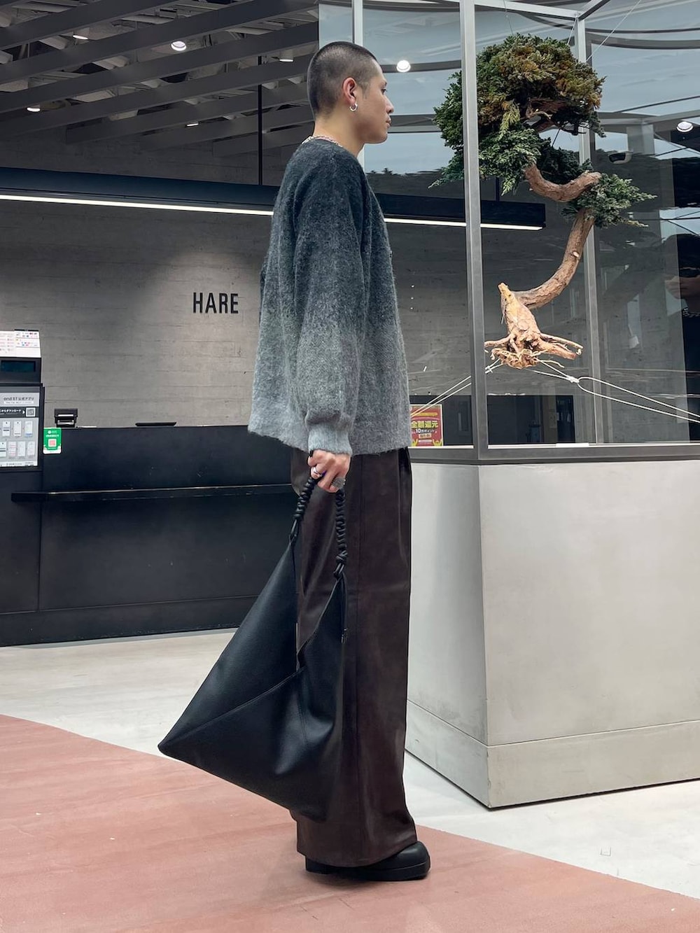 ブラック系のカーディガン/ボレロ、ブラウン系のスラックス、ブラック系のトートバッグを着用したメンズの秋コーディネートの4枚目の写真