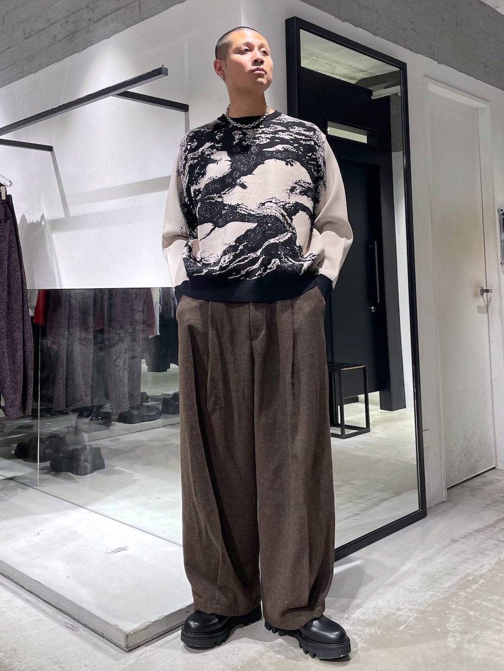 ブラウン系のスラックス、ブラック系のダウンジャケット/コート、ブラック系のドレスシューズを着用したメンズの冬コーディネートの5枚目の写真