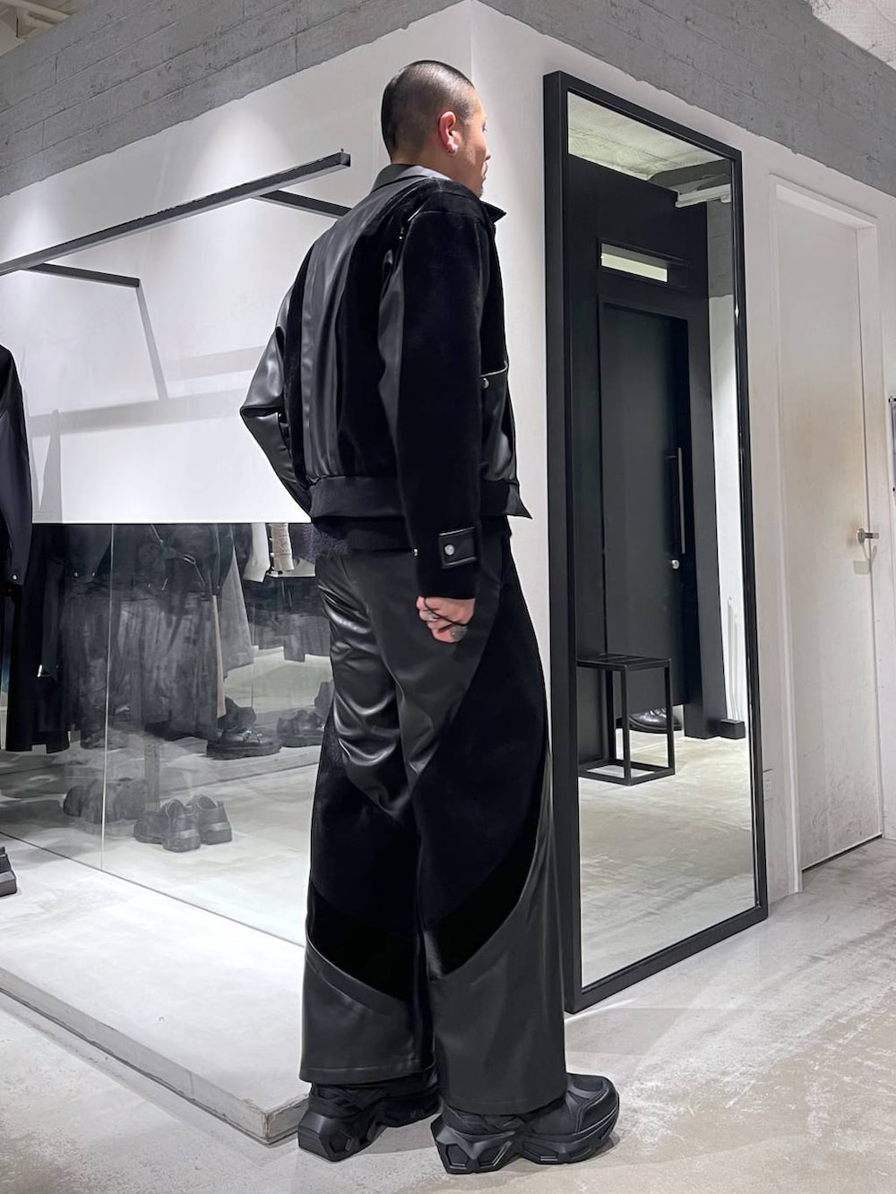 ブラック系のスニーカー、ブラック系のショルダーバッグ、ブラック系のブルゾンを着用したメンズの冬コーディネートの4枚目の写真