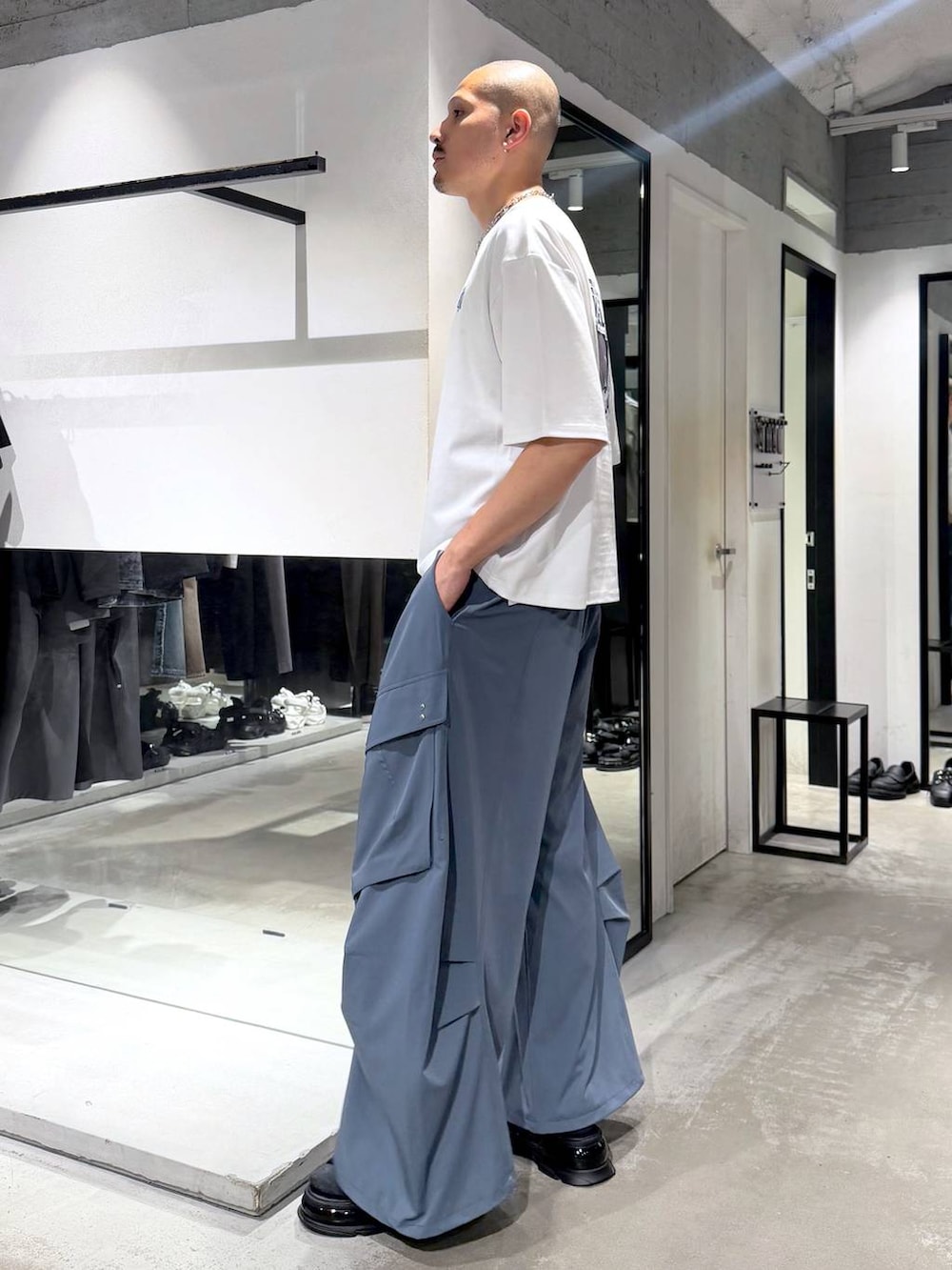 ホワイト系のTシャツ/カットソー、ブルー系のカーゴパンツ、ブラック系のサンダルを着用したメンズの夏コーディネートの2枚目の写真