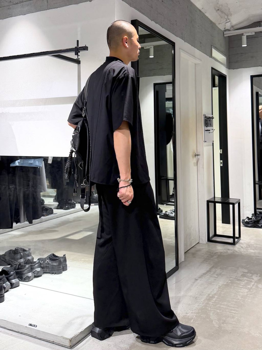 ブラック系のスニーカー、ブラック系のスラックス、パープル系のTシャツ/カットソーを着用したメンズの夏コーディネートの4枚目の写真