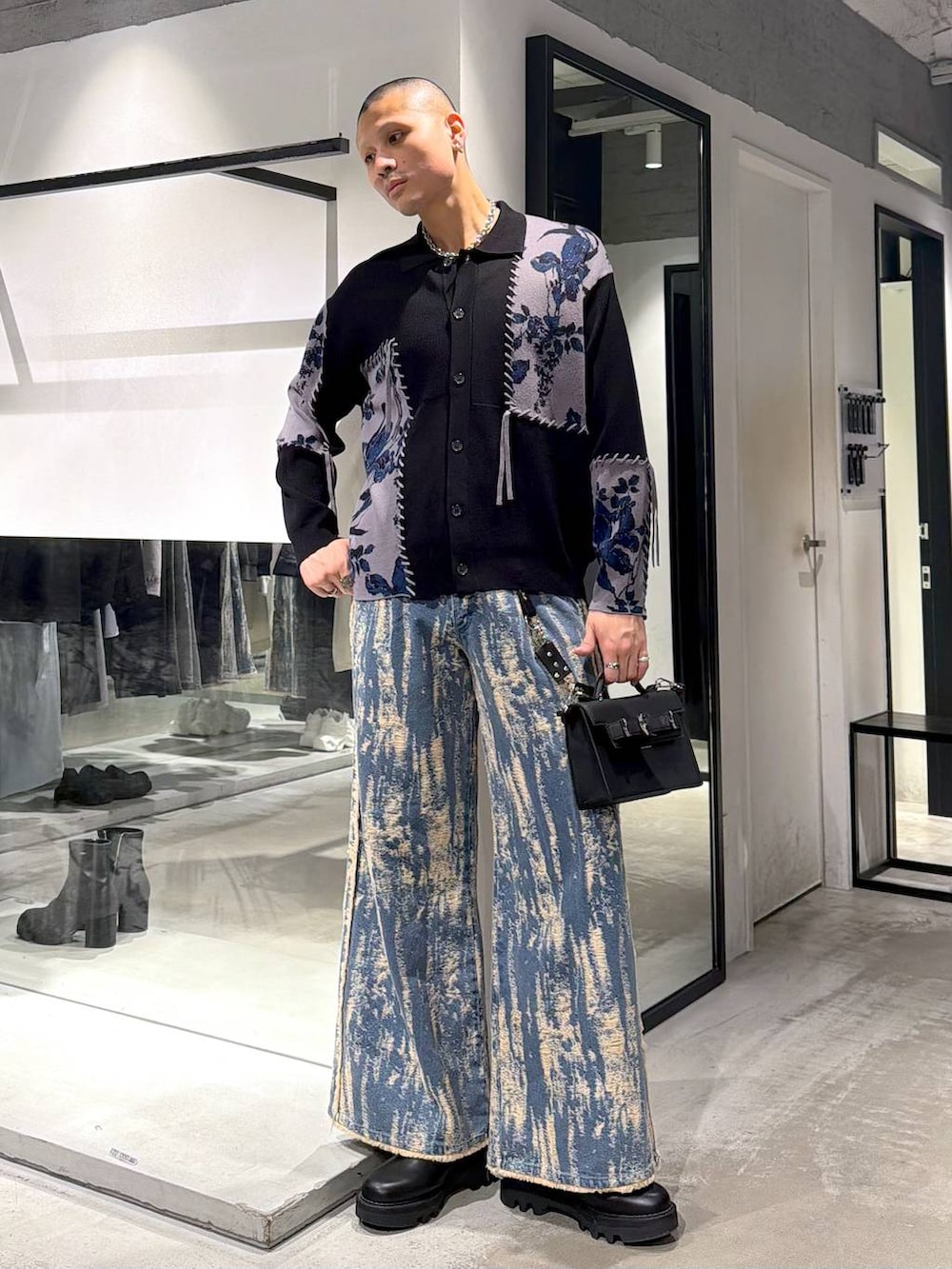 ブラック系のドレスシューズ、ブラック系のハンドバッグ、グリーン系のトレンチコートを着用したメンズの冬コーディネートの5枚目の写真