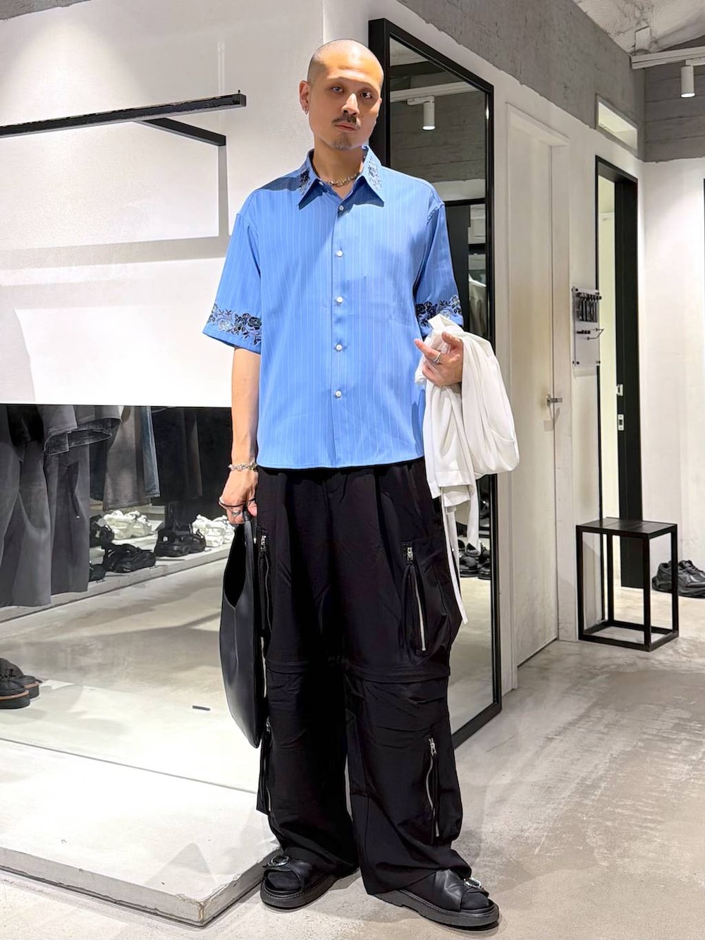 ブルー系のシャツ/ブラウス、ブラック系のトートバッグ、ブラック系のサンダルを着用したメンズの夏コーディネートの5枚目の写真