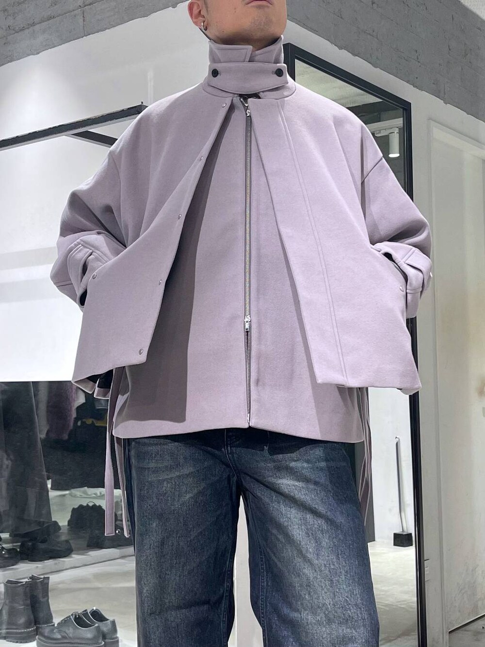パープル系のブルゾン、ブルー系のデニムパンツ、ブラック系のドレスシューズを着用したメンズの秋コーディネートの5枚目の写真