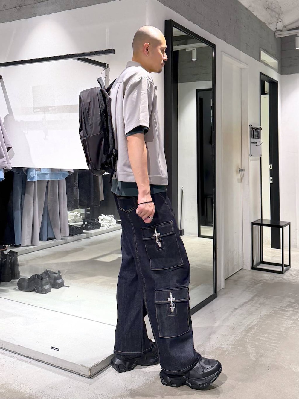 ブラック系のスニーカー、ブラック系のバックパック/リュック、ブルー系のデニムパンツを着用したメンズの夏コーディネートの4枚目の写真