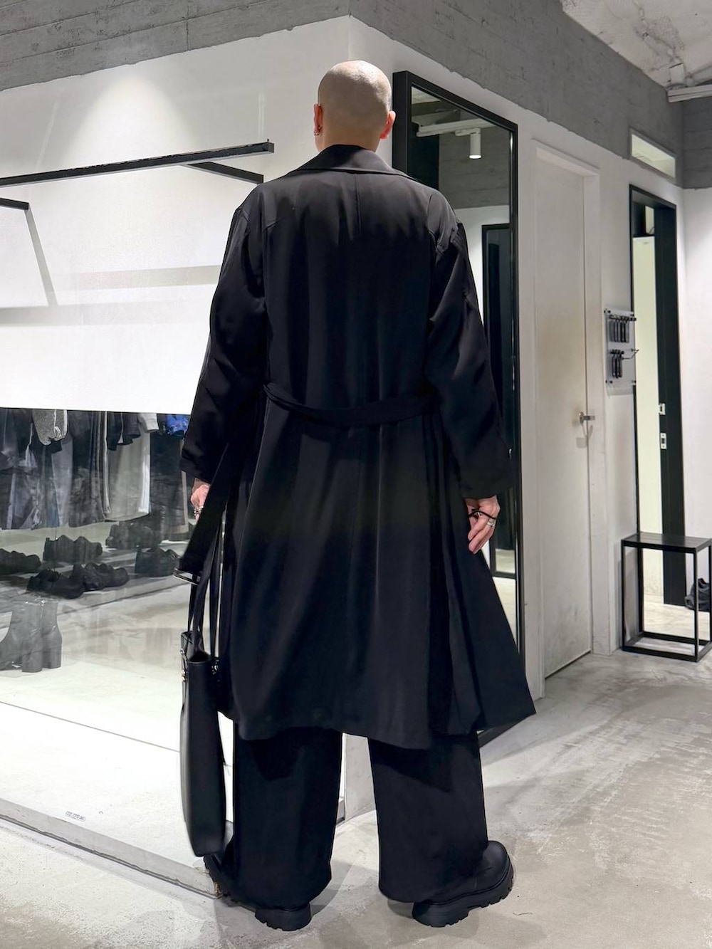 ブラック系のトートバッグ、ブラック系のドレスシューズ、ブラック系のトレンチコートを着用したメンズの春コーディネートの3枚目の写真