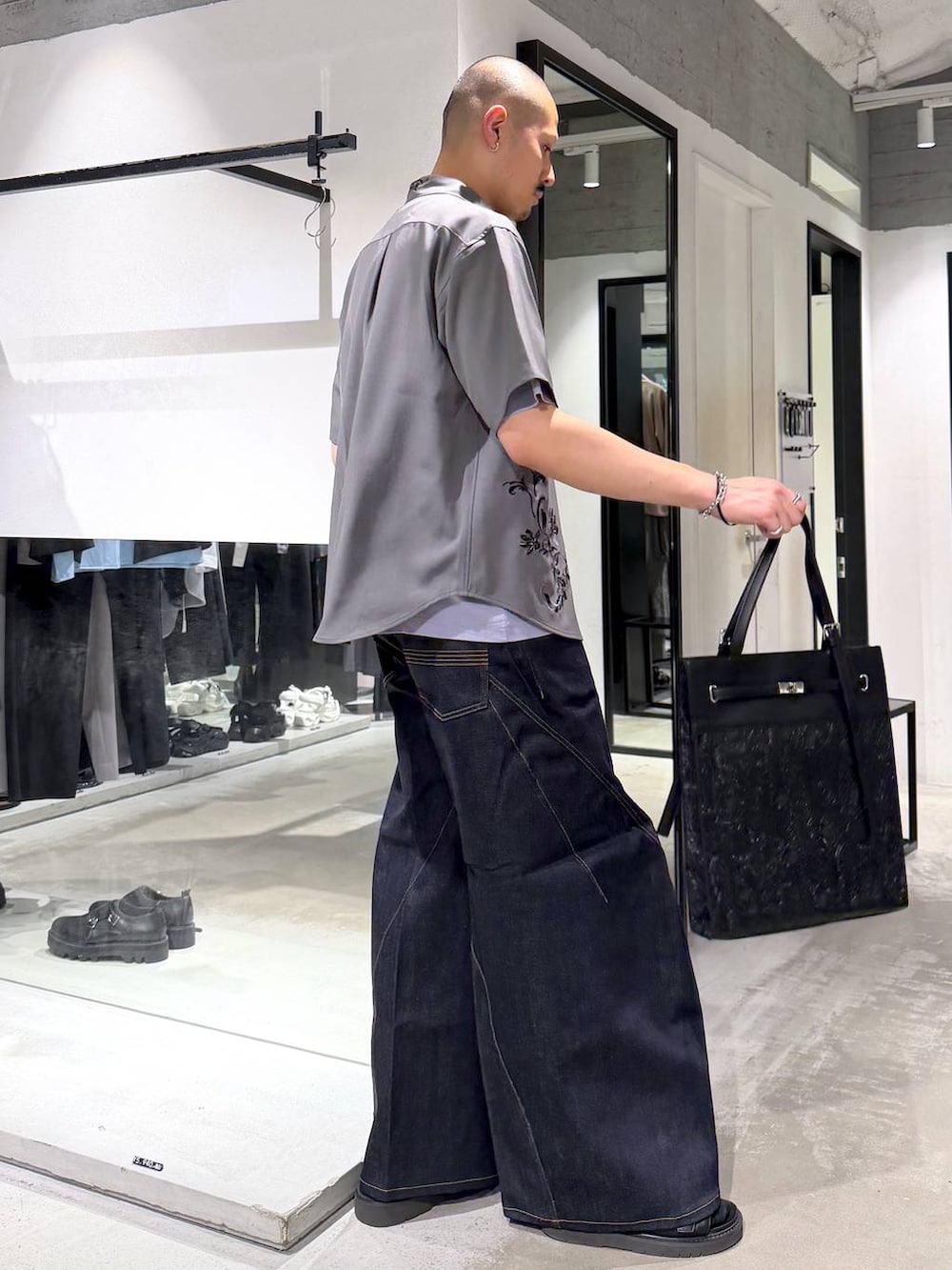 ブルー系のデニムパンツ、ブラック系のサンダル、パープル系のTシャツ/カットソーを着用したメンズの夏コーディネートの4枚目の写真