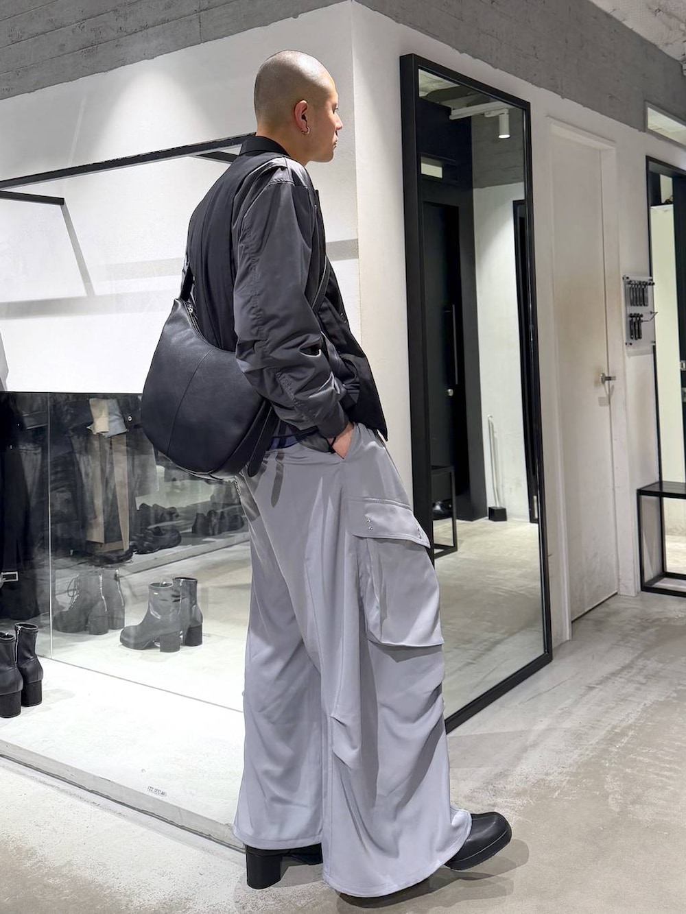 ブラック系のブーツ、ブラック系のショルダーバッグ、ブラック系のテーラードジャケットを着用したメンズの冬コーディネートの4枚目の写真