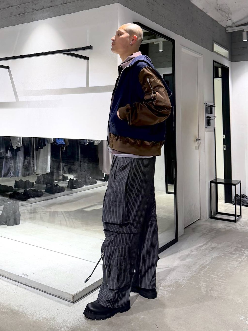 ブラック系のドレスシューズ、グレー系のカーゴパンツ、ブルー系のパーカーを着用したメンズの春コーディネートの2枚目の写真