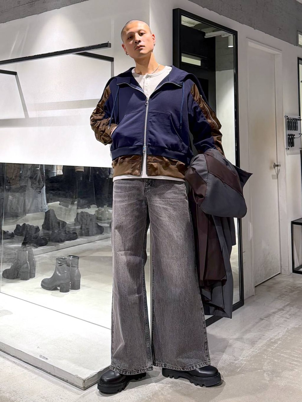 ブラック系のトートバッグ、ブラウン系のデニムパンツ、ブラック系のドレスシューズを着用したメンズの冬コーディネートの4枚目の写真