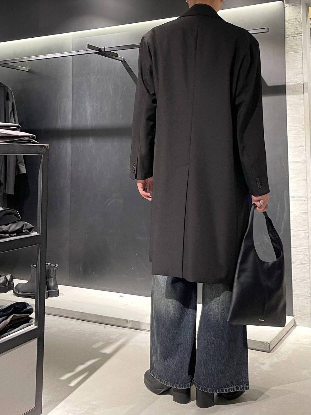 ブラック系のトートバッグ、ブラック系のネクタイ、ブルー系のデニムパンツを着用したメンズの秋コーディネートの3枚目の写真